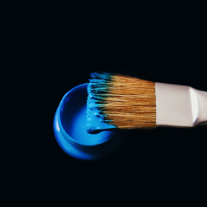 Paintbrush dipped in blue paint